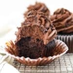 A big bite taken out of these death by chocolate cupcakes showing the chocolate filling