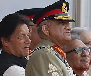 In this March 23, 2019 photo, Pakistan's Army Chief Gen. Qamar Javed Bajwa, center, watches a parade with Prime Minister Imran Khan, left, and President Arif Alvi, in Islamabad, Pakistan.