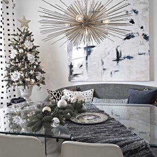 eclectic Christmas dining room with vintage glass table, urchin chandelier and abstract art