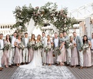 bride and groom on bridge ceremony with bohemian vintage bridesmaid dresses grey groomsmen jackets