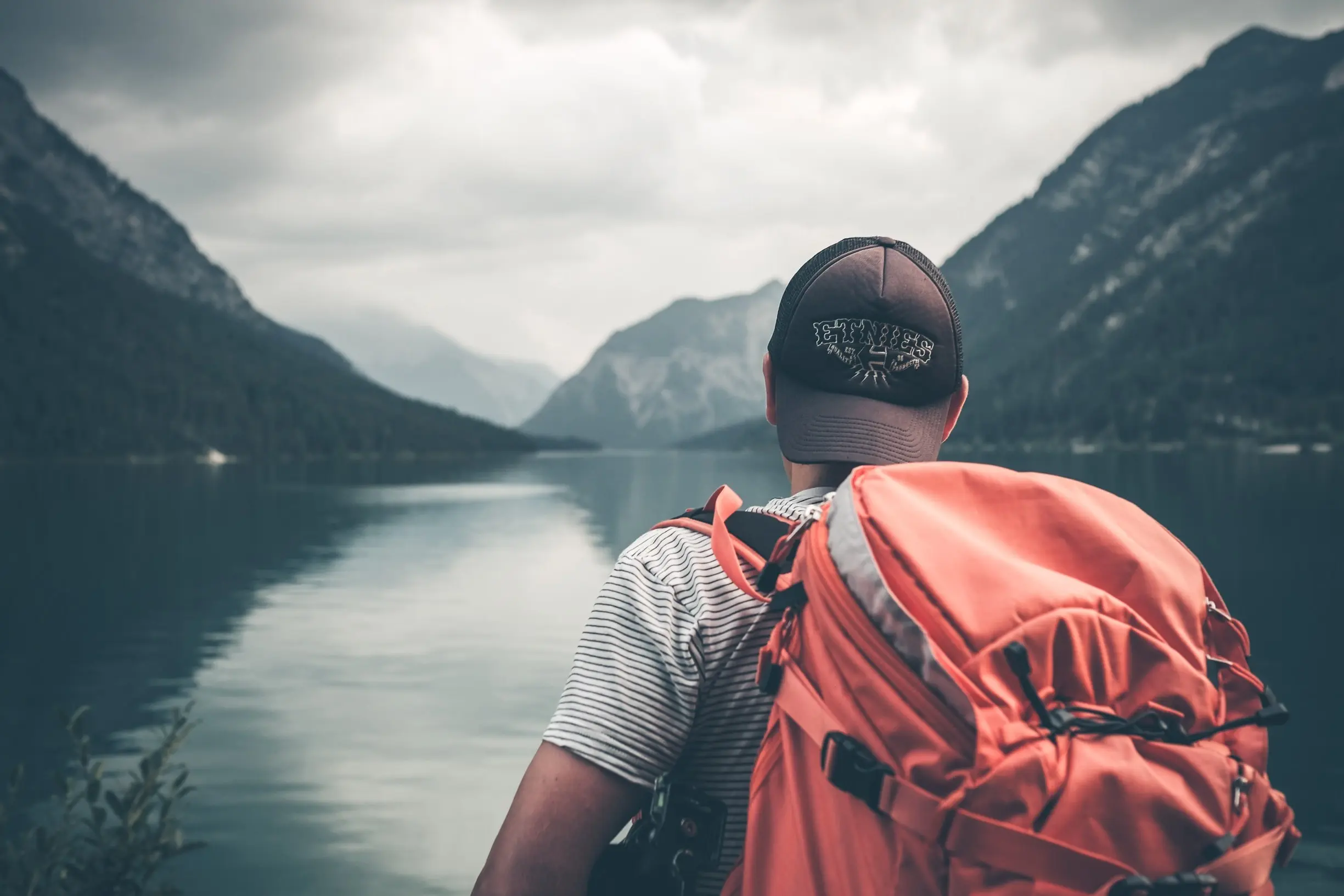 Wanderer schaut auf See mit Bergen