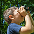 a boy looking up through binoculars