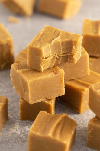 A stack of peanut butter fudge pieces, the top one has a bite taken out