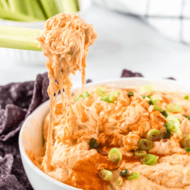 This spicy and delicious baked Buffalo Chicken Dip has the perfect blend of cheese, ranch & hot sauce! Your guests will empty the bowl before you know it!