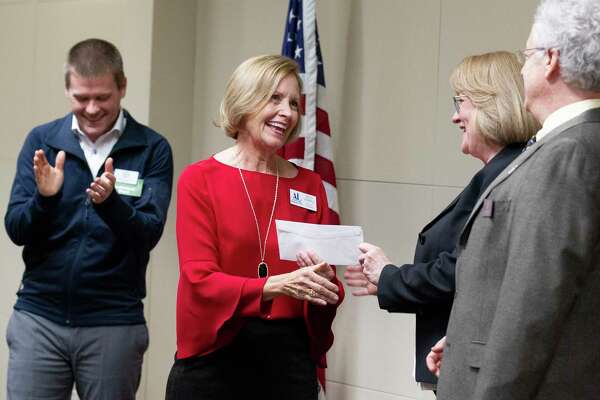 Molly Parkhill with the Montgomery County Assistance League accepts a check for $7,200 from Amanda Trapp, vice president of the Montgomery County Community Foundation, on behalf of the nonprofit during the Montgomery County Community Foundation grant reception at Memorial Hermann The Woodlands Hospital, Thursday, Dec. 5, 2019, in The Woodlands. The foundation granted $184,100 to 43 local nonprofits. The funds for MCAL will be used for new school clothes and literacy under Operation School Bell to help economically disadvantage youth in Montgomery County schools.