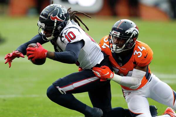 Houston Texans wide receiver DeAndre Hopkins (10) is tackled by Denver Broncos strong safety Will Parks (34) as he makes a first down reception during the first quarter of an NFL football game at Broncos Stadium at Mile High on Sunday, Nov. 4, 2018, in Denver.