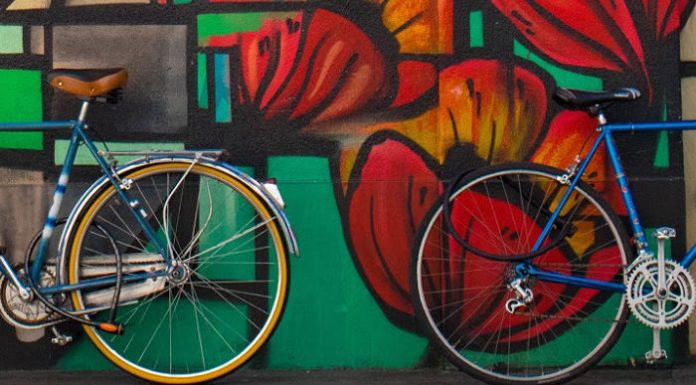 Bikes in front of a wall of graffiti.