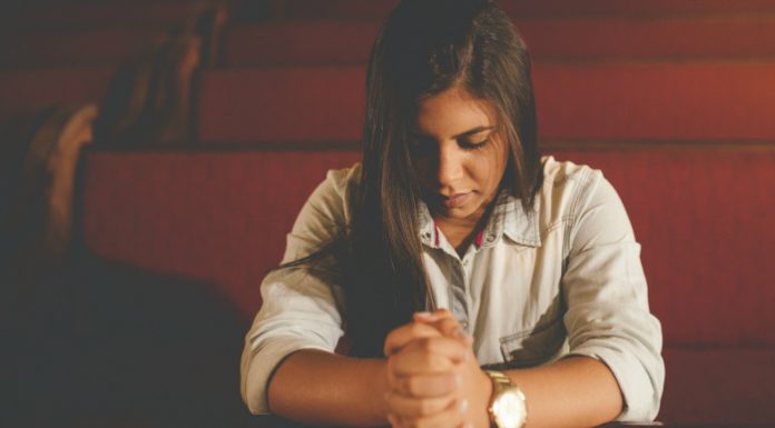 Girl sitting in church pews without sacrament