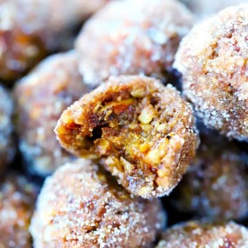 a close up photograph of a gingerbread energy ball with a bite taken out of it.