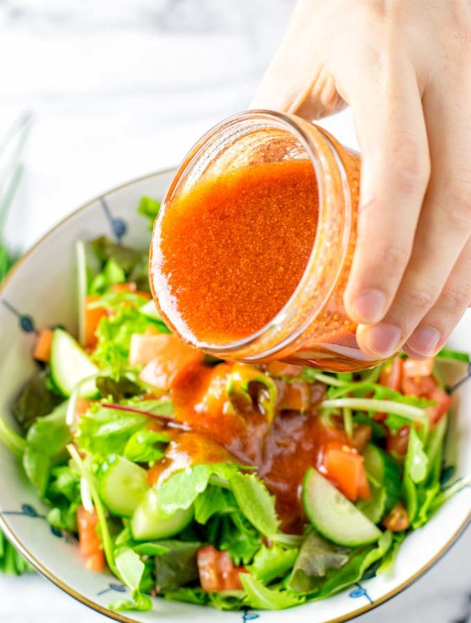 Pouring the Catalina Dressing over fresh salad.