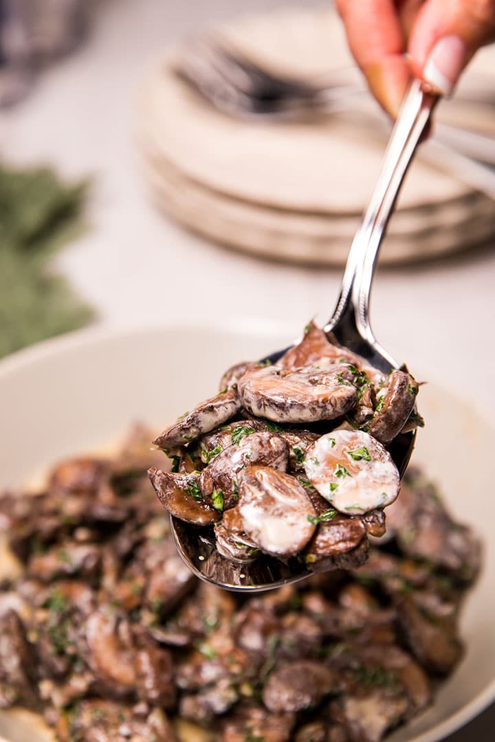 Creamy Garlic Mushrooms being served with a serving spoon