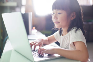 Assessing students over time using digital tools also helps save teachers' time, like this little girl on a laptop.