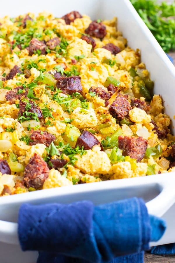 A white baking dish full of homemade cornbread dressing with sausage.