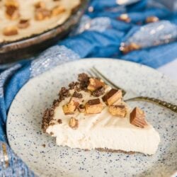 Side view of a slice of Creamy Peanut Butter Pie with a whole pie in the background