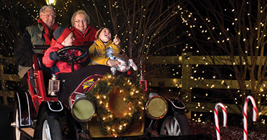 Grandparents and grandkids riding a classic car in Christmas Candylane