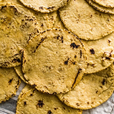 Everything you need to know about how to make corn tortillas at home! What you need, step-by-step process from start to finish and how to keep them warm. They're easy to make and perfect for taco night!