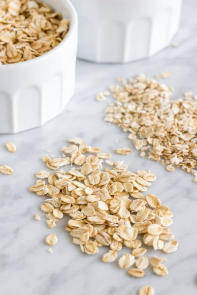 Close up rolled oats beside quick oats on a marble surface