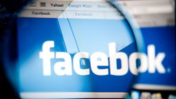 Foto durch die Brille eines Nutzers, der das Facebook-Logo betrachtet.