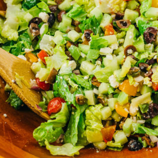 close up view of tossing the chopped salad