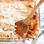 apple cobbler in a pan with a wooden spoon